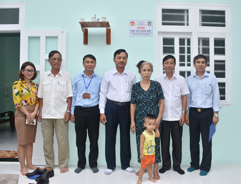 Ông Phạm Văn Triêm, Chủ tịch HĐQT Công ty CP Đầu tư và Xây dựng  Tân Phước Thịnh (giữa) trao nhà đại đoàn kết cho gia đình bà Lê Thị Sáu (thứ 3 từ phải qua).