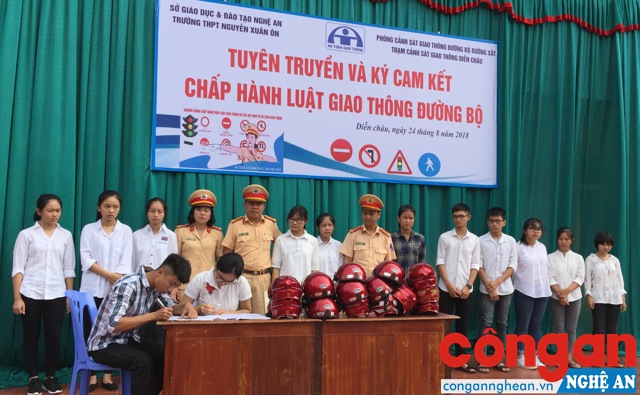 Tổ chức ký cam kết về chấp hành Luật Giao thông đường bộ và trao tặng mũ bảo hiểm cho các em học sinh