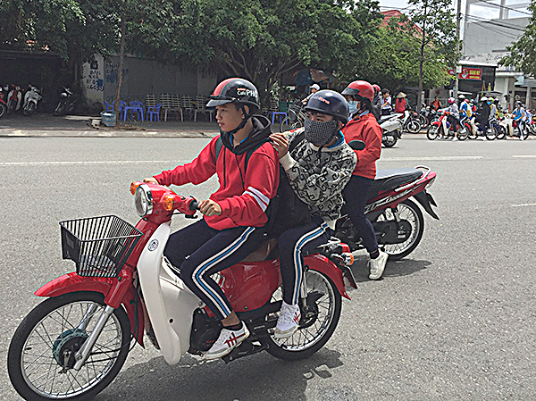Học sinh Trường THPT Nguyễn Bỉnh Khiêm (TP.Bà Rịa) đội mũ bảo hiểm đúng cách khi tham gia giao thông bằng xe máy.