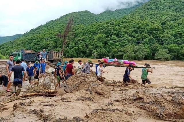 Thanh niên trai tráng cáng thi thể một nạn nhân bị lũ cuốn ở huyện Mường Lát.