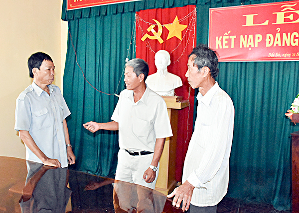 Ông Phạm Văn Phước (giữa), Bí thư Chi bộ khu phố Thanh Bình trao đổi với đảng viên Nguyễn Thanh Dũng (bìa trái) người vừa được trao quyết định công nhận đảng viên chính thức vào tháng 8-2018.