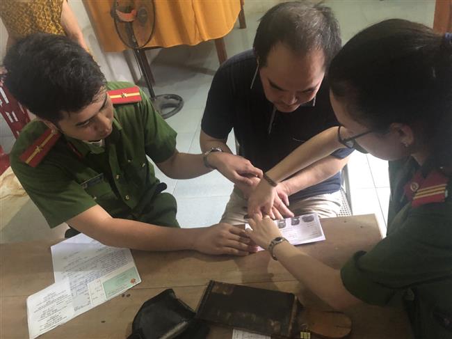 Cán bộ CATP Vinh đang làm thủ tục cấp phát CMND cho bà Thảo và con trai.
