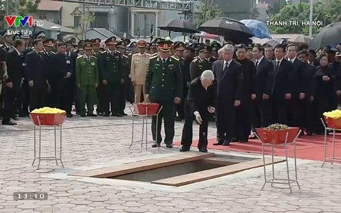 Tổng bí thư Nguyễn Phú Trọng dẫn đầu đoàn lãnh đạo cấp cao thả nắm đất và những cánh hoa cúc đầu tiên xuống huyệt mộ. 