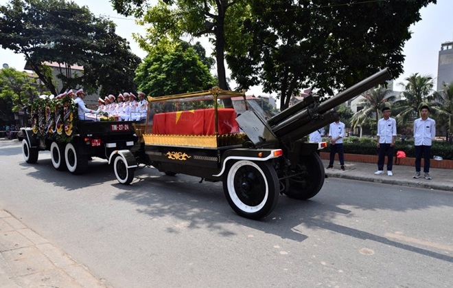 Đoàn xe đưa linh cữu cố Tổng bí thư về tới quê nhà, xã Đông Mỹ, Thanh Trì. Người dân cùng các em học sinh thành kính đứng bên đường chờ đón.