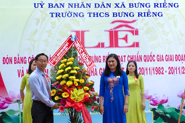 Bà Đinh Thị Trúc My, Phó Chủ tịch UBND huyện Xuyên Mộc tặng hoa chúc mừng trường THCS Bưng Riềng.