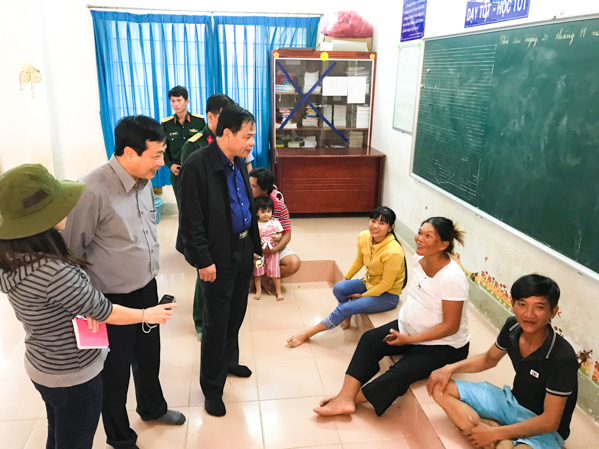 Bộ trưởng Nguyễn Xuân Cường thăm hỏi người dân đang tránh bão tại trường Tiểu học Lộc An. Ảnh: Minh Tâm