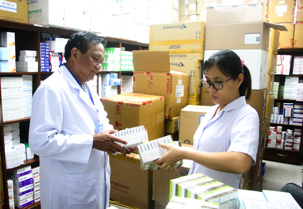 Bác sĩ Nguyễn Thế Bảo (bìa trái), Phó Giám đốc Trung tâm Y tế huyện Long Điền kiểm tra số lượng thuốc tại kho dược.