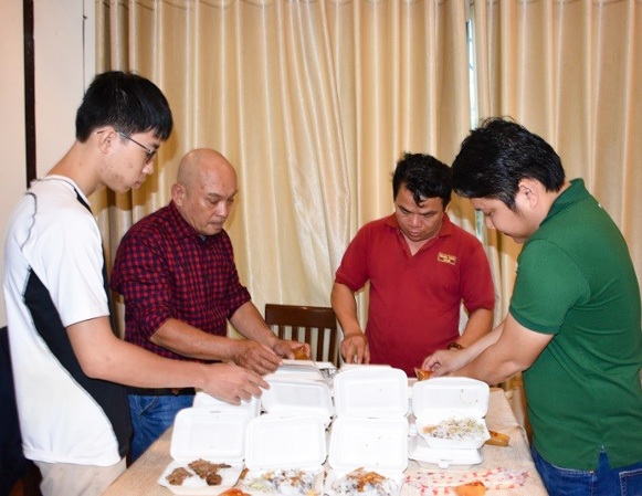 Anh Phạm Anh Hoàng, chủ cửa hàng bánh cuốn Lá (người thứ 2, bên trái) chuẩn bị bánh cuốn và bún thịt nướng cho người dân đến tránh bão tại khách sạn Fita Cao Su. 