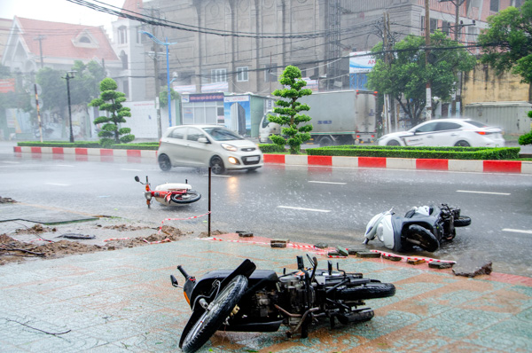 Các phương tiện xe máy lưu thông trên đường gặp gió to đổ ngã trên đường Lê Hồng Phong (TP. Vũng Tàu) sáng 25-11. Ảnh: MẠNH THẮNG