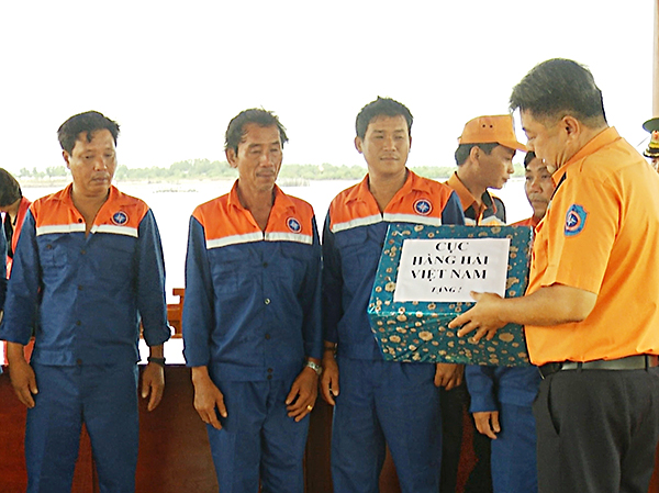 Ông Lương Trường Phi, Phó Giám đốc Trung tâm PHTKCNHH khu vực 3 trao quà của Cục Hàng hải Việt Nam cho các ngư dân gặp nạn.