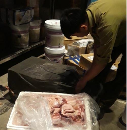 Lực lượng Quản lý thị trường kiểm tra số chân giò lợn không rõ nguồn gốc.