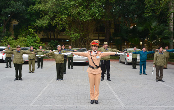 Cán bộ CSGT hướng dẫn thực hành các động tác chỉ huy điều khiển giao thông cho lực lượng bảo vệ dân phố.