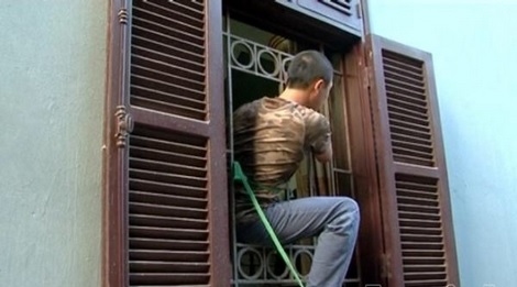 Cơ quan Công an đưa một đối tượng tới hiện trường thực hiện lại hành vi phá song sắt cửa sổ đột nhập trộm cắp tài sản.