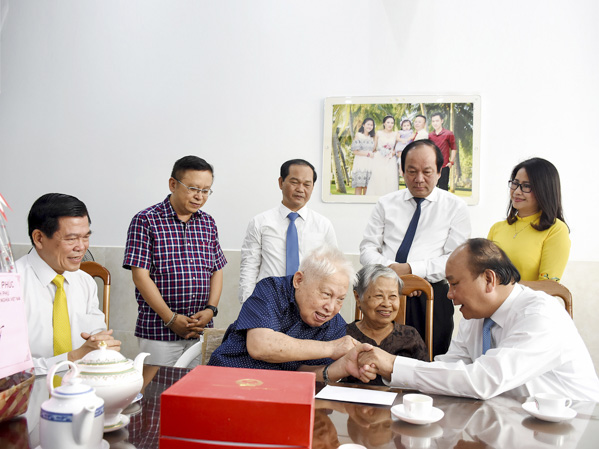 Thủ tướng Nguyễn Xuân Phúc cùng các đồng chí lãnh đạo tỉnh thăm gia đình ông Nguyễn Bá Mùi (SN 1931, thương binh hạng 1/4, ở E4-2/25, Khu đô thị Chí Linh, phường 10). Ảnh: MẠNH THẮNG