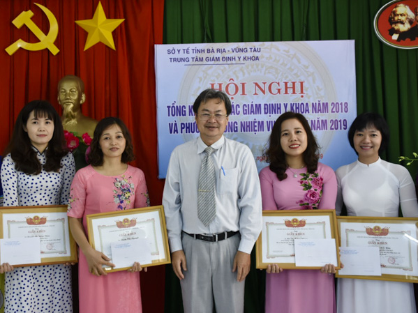 Bác sĩ Trần Văn Bảy, Giám đốc Trung tâm GĐYK trao giấy khen cho cán bộ, viên chức đạt thành tích xuất sắc trong năm 2018.