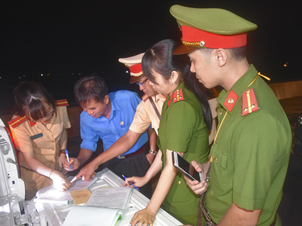 Lực lượng công an hướng dẫn người vi phạm ký biên bản tạm giữ phương tiện.
