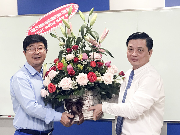 Đồng chí Nguyễn Thành Long, Ủy viên Ban Thường vụ Tỉnh ủy, Phó Chủ tịch UBND tỉnh tặng hoa chúc Tết lãnh đạo Công ty TNHH Posco SS Vina.