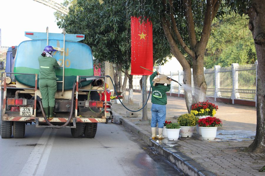 Công nhân cây xanh thành phố cần mẫn chăm sóc hoa để mang lại nụ cười cho người dân