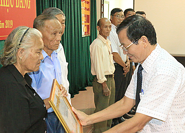 Đồng chí Lương Trí Tiên, Ủy viên Ban thường vụ Tỉnh ủy, Trưởng Ban Nội chính tỉnh ủy trao Huy hiệu Đảng cho các đảng viên.