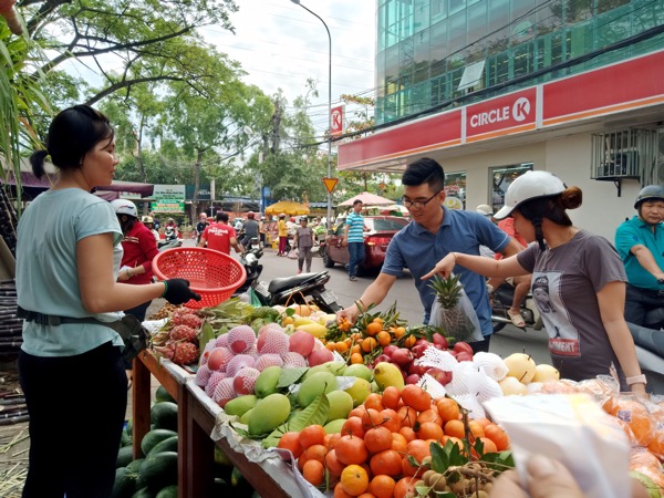 Khách hàng mua trái cây tại chợ Rạch Dừa.
