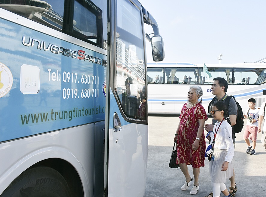 Du khách lên xe bus đi tham quan các điểm du lịch.