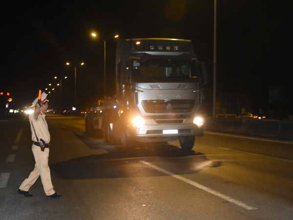 Lực lượng CSGT Công an tỉnh ra hiệu dừng xe tải để kiểm tra nồng độ cồn và ma túy đối với lái xe.