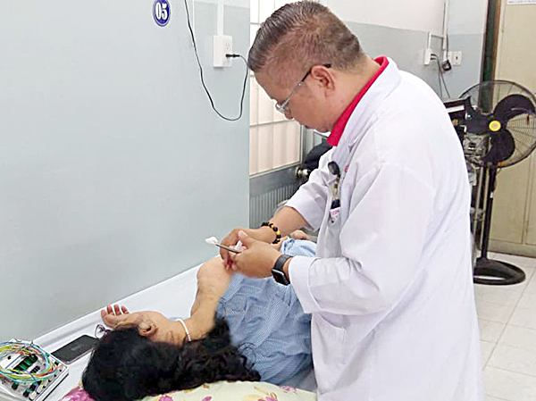 Bác sĩ Nguyễn Trường Sơn đang thực hiện phương pháp Thủy châm điều trị cho bệnh nhân.