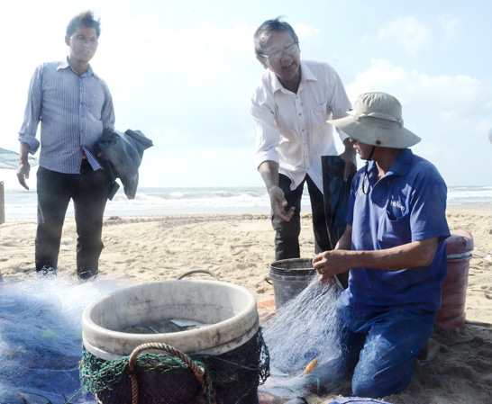 Thành viên Tổ Tự quản bảo vệ môi trường biển khu phố Hải Sơn  (thị trấn Phước Hải) phát bao rác cho các chủ thuyền thúng.