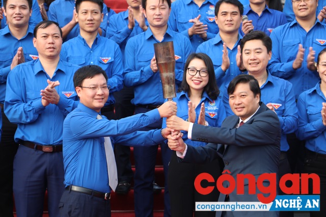 Đồng chí Lê Hồng Vinh, Phó Chủ tịch UBND tỉnh trao ngọn đuốc cho đồng chí Phạm Tuấn Vinh, Bí thư Tiỉnh đoàn...