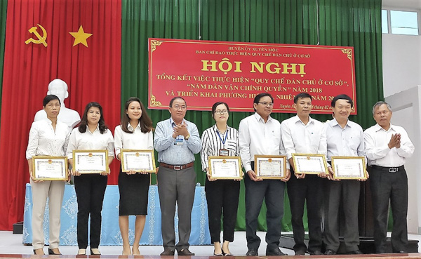Ông Đặng Thanh Minh (giữa), Chủ tịch UBND huyện Xuyên Mộc trao Giấy khen cho các tập thể đạt thành tích xuất sắc trong triển khai thực hiện QCDCCS và dân vận chính quyền năm 2018.