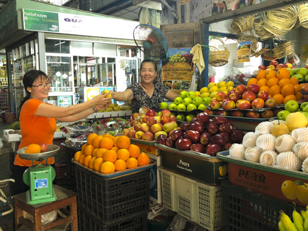 Bà Lê Thị Kim Chi, bán trái cây tại chợ Vũng Tàu (chợ đạt tiêu chuẩn văn minh thương mại) vui vẻ với khách.