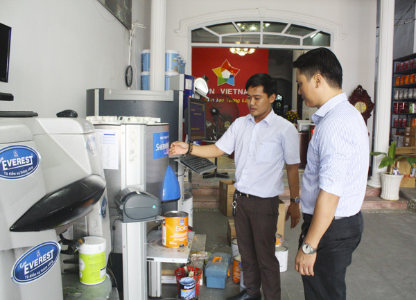 Nhân viên Công ty TNHH TM-DV-XD - Trung tâm pha màu Kim Đạt (TP. Vũng Tàu) trao đổi với khách hàng về cách pha màu sơn. 