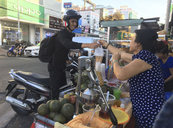 Khách hàng mua nước ép cam trên đường Trương Công Định, TP. Vũng Tàu. Ảnh: KIM HỒNG