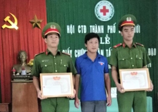 Bí thư Thành đoàn Đồng Hới trao Giấy chứng nhận tuổi trẻ dũng cảm cho 02 đồng chí.