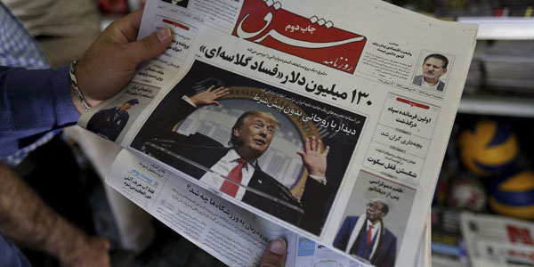 Người Iran theo dõi báo chí thông tin về lệnh trừng phạt từ Mỹ. Ảnh: AFP