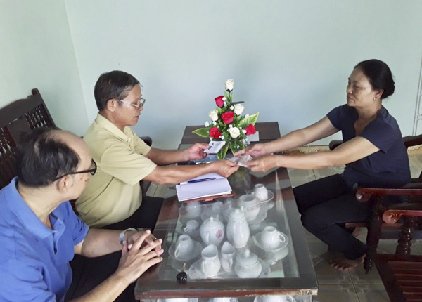 Ông Phạm Văn Long (trưởng ấp Phước Thắng, xã Phước Tỉnh) trực tiếp nhận hồ sơ, trao thẻ BHYT cho người dân đăng ký tham gia.