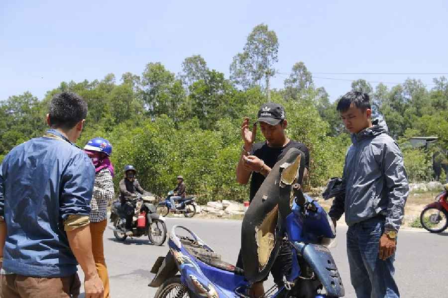 Cán bộ điều tra Công an TP Tam Kỳ đưa đối tượng Trọng (áo đen) đến hiện trường  thực nghiệm lại cảnh cướp tiền