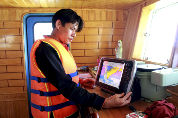 Ngư dân điều khiển máy thông tin và GSHT trên tàu cá.