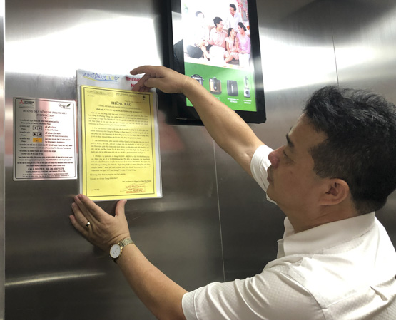 Anh Phí Đức Giang, Trưởng Ban quản lý chung cư Vũng Tàu Melody dán thông báo nội quy kinh doanh lưu trú trong hệ thống thang máy chung cư. 