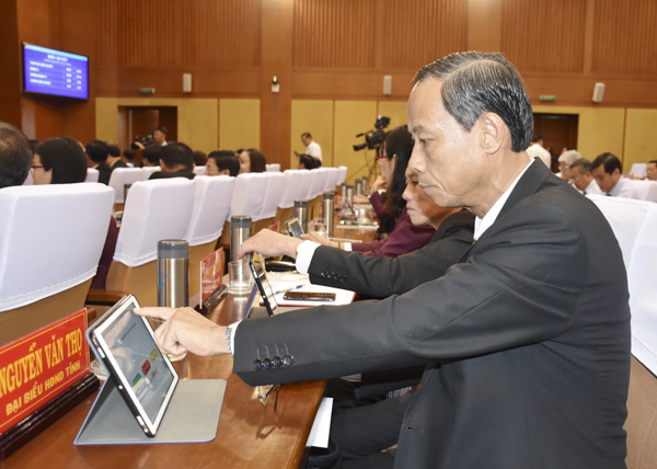 Đại biểu HĐND tỉnh tham gia biểu quyết thông qua các nghị quyết  trên hệ thống máy tính bảng.
