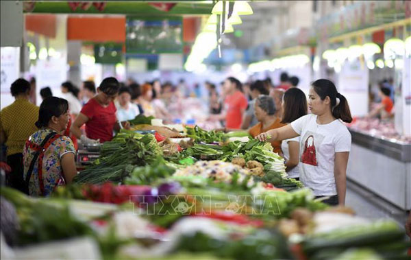 Người dân mua sắm tại một khu chợ ở Hải Nam, Trung Quốc. (Nguồn AFP)