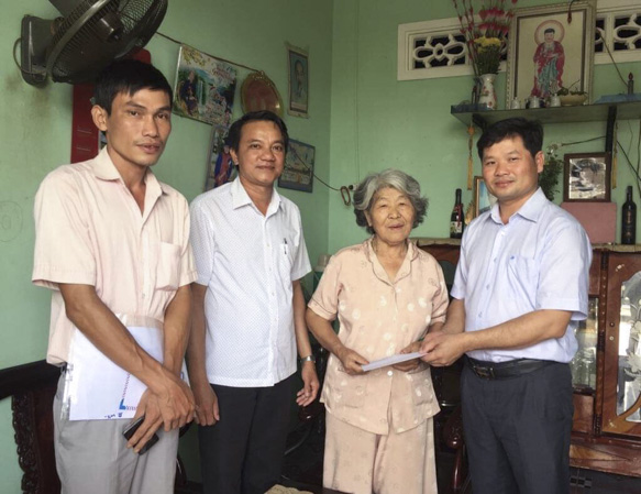 Ông Lê Thanh Liêm, Phó Chủ tịch UBND huyện Châu Đức (ngoài cùng, bên phải) thăm, tặng quà cho bà Đậu Thị Nhung (SN 1944, thôn Sông Xoài 3, xã Láng Lớn, là đảng viên trên 50 năm tuổi Đảng).