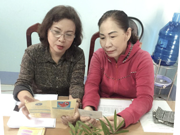 Chị Cao Thị Ngọc Điệp (bên trái), Chủ tịch Hội LHPN xã Bình Giã, huyện Châu Đức tư vấn về lợi ích khi tham gia BHYT cho chị Trần Thị Nguyệt. 