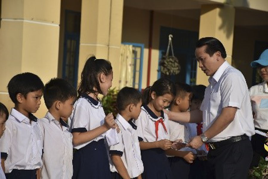 Đại diện Tập đoàn Hưng Thịnh trao học bổng cho các em học sinh nghèo hiếu học.