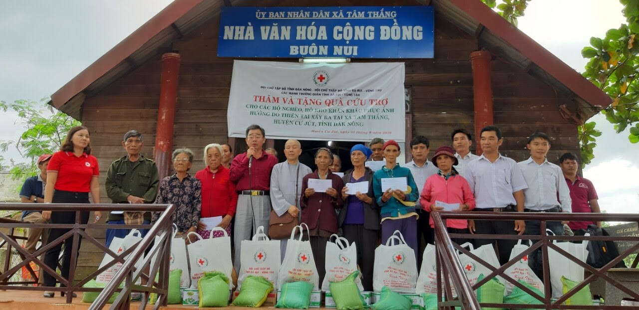 Ông Lê Công Hậu, Chủ tịch Hội Chữ thập đỏ tỉnh (thứ 5 từ trái qua) trao quà và tiền cho bà con Êđê nghèo có hoàn cảnh đặc biệt khó khăn ở xã Tâm Thắng, huyện Cư jut, tỉnh Đắk Nông. 