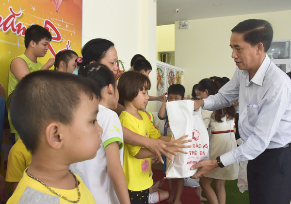 Ông Trần Quốc Khánh, Phó Giám đốc Sở LĐTBXH tặng quà Trung thu cho các bé tại Trung tâm giáo dục hòa nhập Phước An. Ảnh: TUYẾT MAI