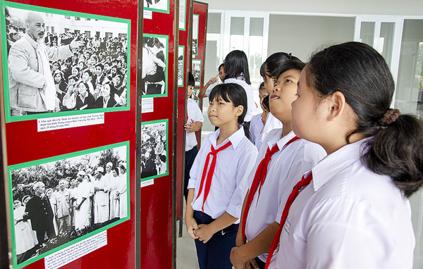 Các em HS xem triển lãm ảnh về Chủ tịch Hồ Chí Minh tại Hội thi “Tự hào Đảng quang vinh”.