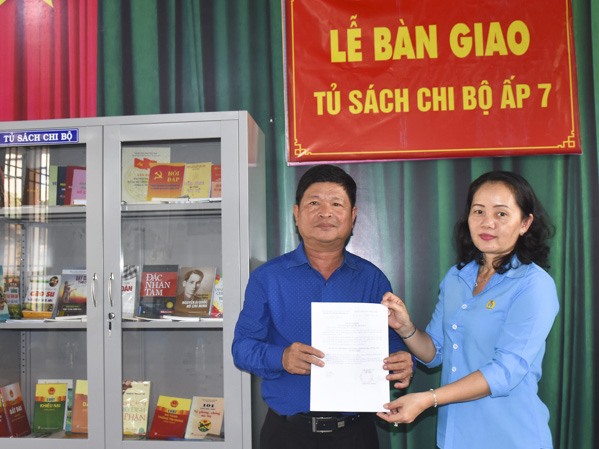 Bà Tạ Thị Hồng Hà, Phó Chủ tịch LĐLĐ tỉnh trao Quyết định tặng tủ đựng sách và sách cho Chi bộ ấp 7, xã Hòa Bình. 