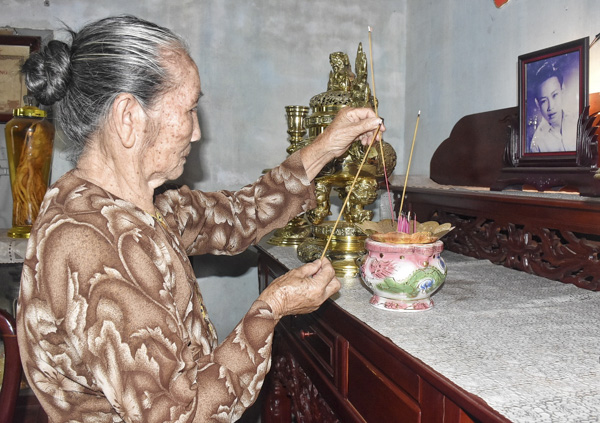 Bà Nguyễn Thị Dưa, vợ Anh hùng lực Lượng vũ trang Nhân dân - liệt sĩ Nguyễn Thanh Đằng, thắp hương trên bàn thờ của chồng.