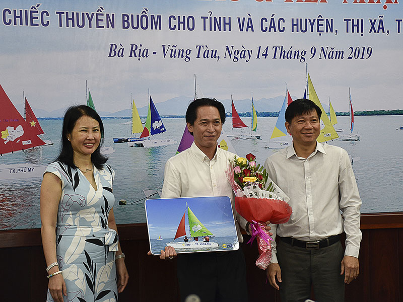 Ông Trần Văn Tuấn, Phó Chủ tịch UBND tỉnh tặng hoa và Bảng tượng trưng du thuyền cho ông Huỳnh Đức Dũng, Phó Giám đốc Sở VH-TT.